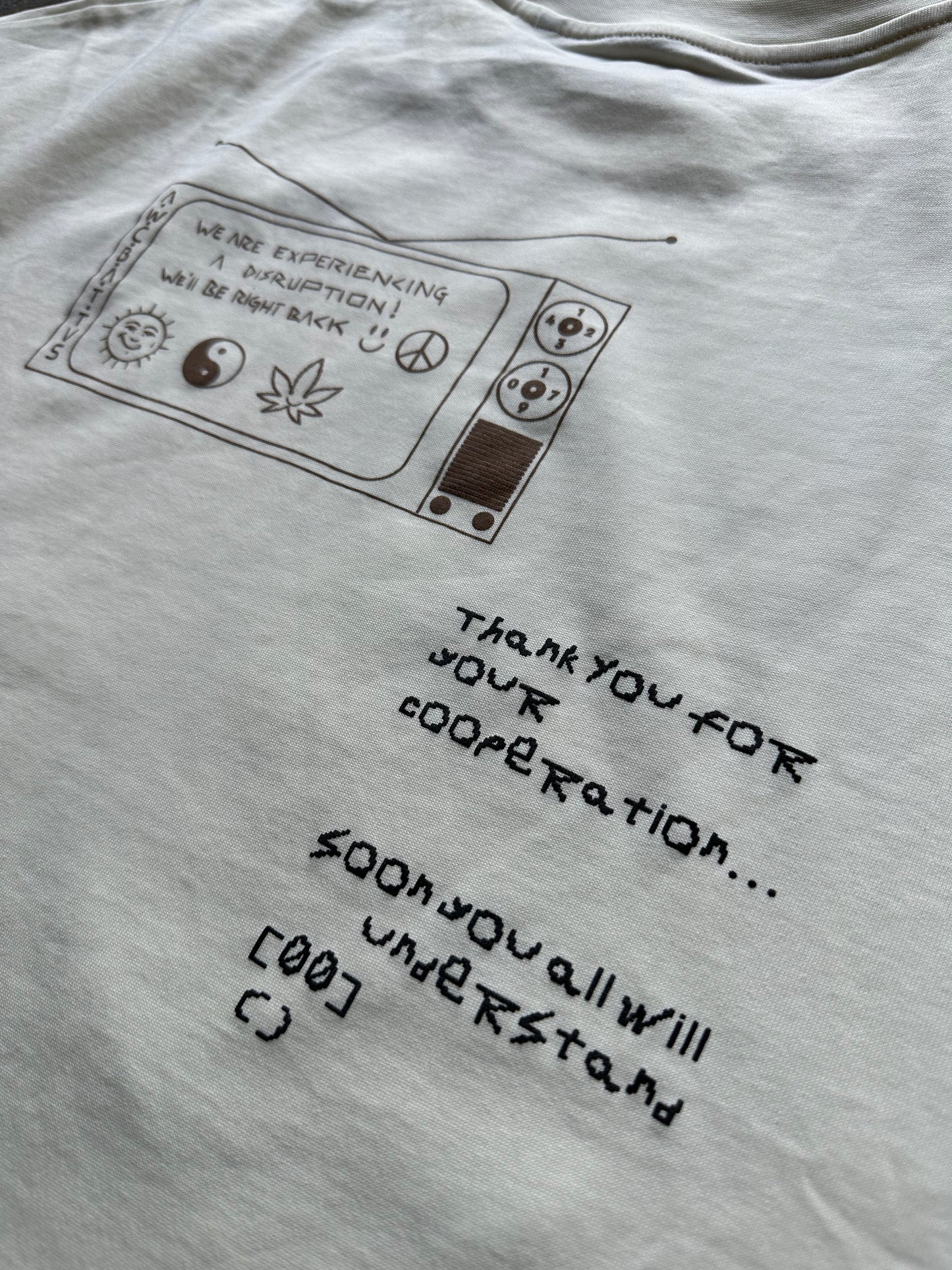 cream t shirt, back image, graphic close up, puff print